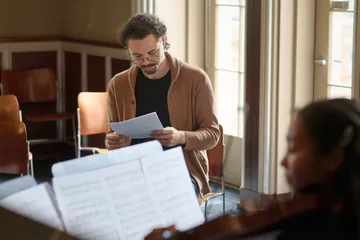 Tyler, listening to a violinist student rehearsing a score during a workshop.