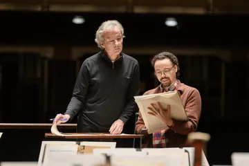 Franz Welser-Möst, conductor of the Cleveland Orchestra, giving notes at rehearsal to Tyler, on stage in Severance Music Center.